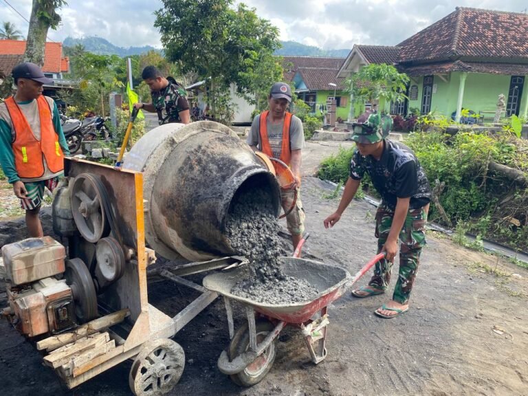 Anggota Satuan Tugas (Satgas) TMMD dari Yonzipur 5/Abw bersama warga Dusun Krajan 1A, Desa Lebakharjo, Kecamatan Ampelgading, bahu-membahu melanjutkan pekerjaan pengecoran jalan rabat beton,