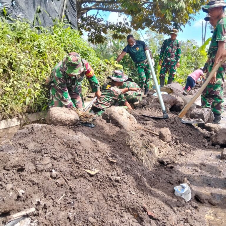 Personel Gabungan Kodim 0821 dan Yonif 527/BY Bersihkan Selokan di Jalur Vital Supiturang.